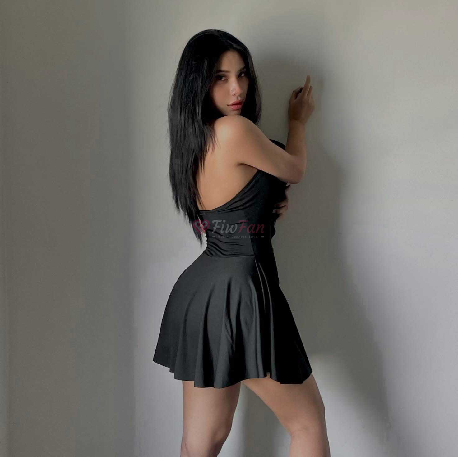สาวรับงาน Ingday ในชุดเดรสสีดำ โพสท่าข้างผนัง สไตล์เรียบหรู