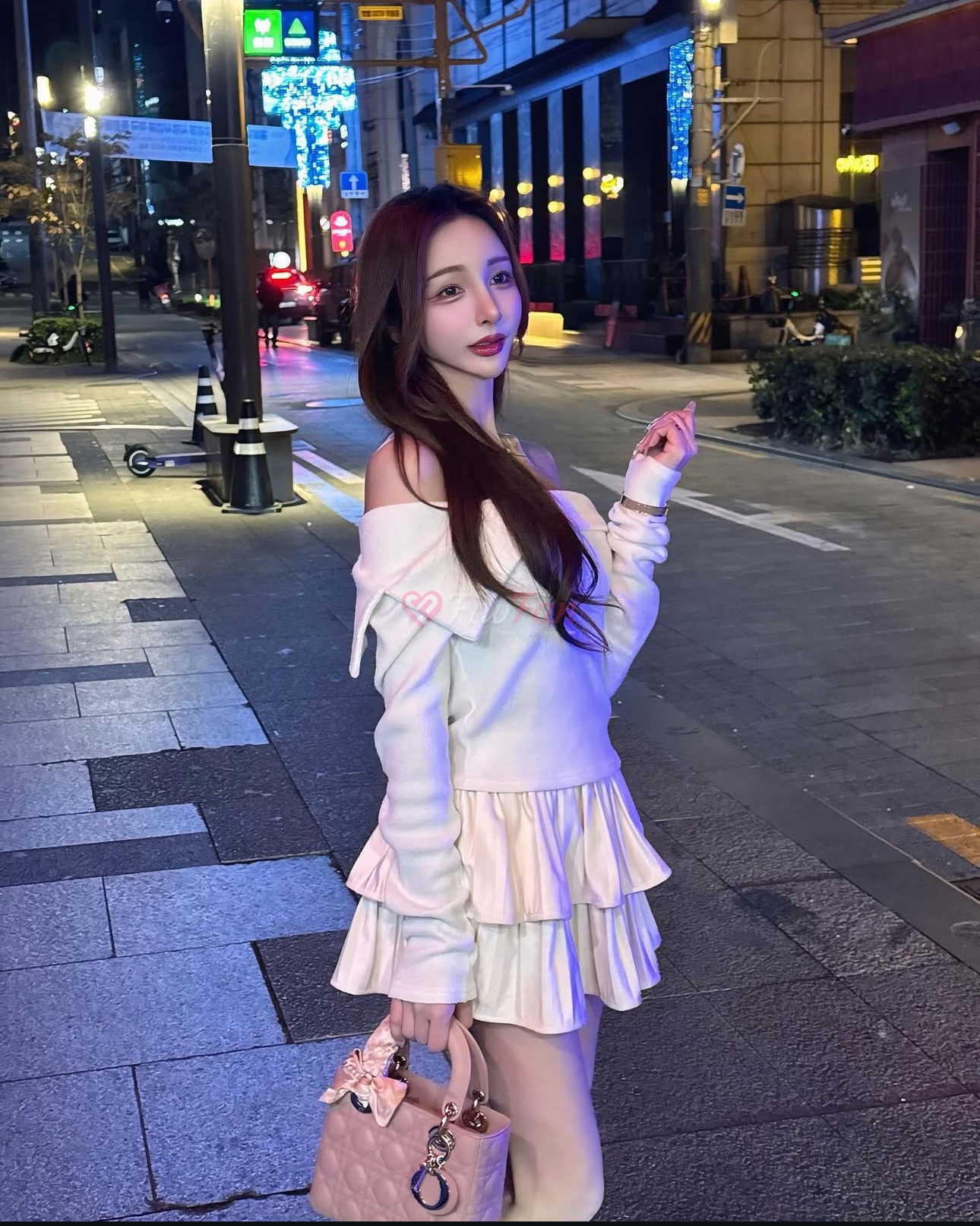 Naeun ในชุดเดรสแขนกุดสีขาว ถือลูกไม้สีชมพู โพสท่ากลางคืนในสุขุมวิท