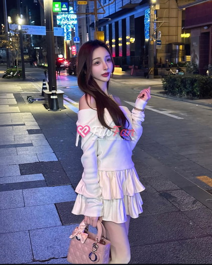 Naeun ในชุดเดรสแขนกุดสีขาว ถือลูกไม้สีชมพู โพสท่ากลางคืนในสุขุมวิท